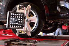 Close up image of a black car on an automotive alignment systems