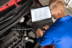 Man using automotive diagnostic equipment to analyze a problem with a car