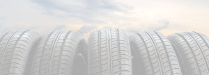 Color faded image of 5 vertical tires in a row in front of clouds