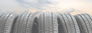 Five vertical tires in a row in front of clouds