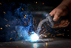 Close up image of a man using welding equipment