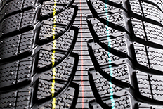 Close up image of tire treads with three vertical lines which are yellow, red, and blue