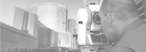 Black and white image of man using geospatial equipment to look at buildings