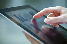 Close up of a person using a tablet to look at technical data