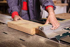 Color image of a man using a woodworking table saw 2