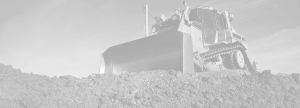 Black and white image of a bulldozer on a hill of gravel
